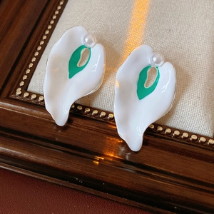 Detail of vintage enamel leaf earrings with white and green petals and pearls