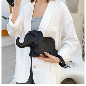 Detail view of the black elephant crossbody bag worn by a model in a minimalist setting
