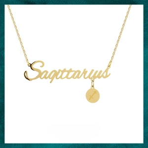 Detailed macro of golden Sagittarius script necklace with round zodiac charm in steel