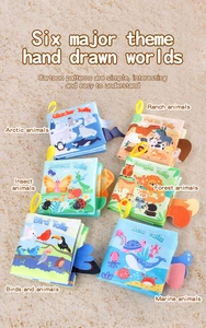 Close-up of sensory baby cloth books with colorful 3D animal tails on a beige carpet
