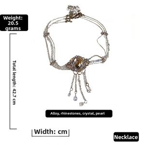 Détail du choker baroque avec pierre brune ovale, perles et franges de chaînes fines