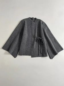 Flat lay of a charcoal grey knit coat featuring wide split sleeves and waist tie detail