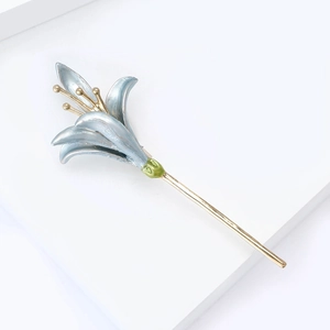 Detailed view of a blue enamel lily flower hairpin with a golden metal stem and pistil