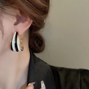 Detailansicht der Vintage-Ohrringe mit schwarz-weißen Emaille-Streifen am Modellohr