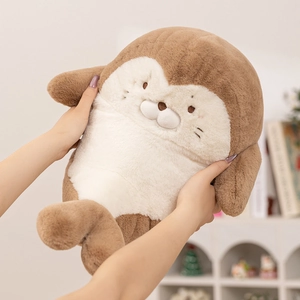 Soft plush seal doll in warm brown and cream white being held by hands in a home setting