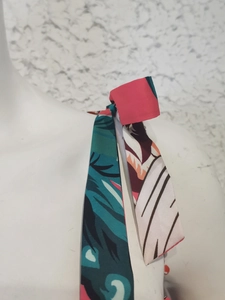 Detail shot of tropical leaf print strap tied on the shoulder of a summer dress
