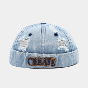 Close-up of CREATE embroidery and distressed denim texture on a brimless docker hat