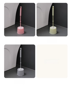 Detailed view of long-handled toilet brush set in pink, green, and grey with holders