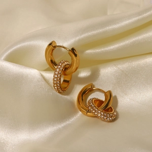Elegant gold double hoop earrings with sparkling rhinestones on beige silk fabric