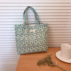 Gros plan du sac en coton avec motifs floraux et étiquette tissée sur table en bois