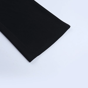Detailed close-up of double-needle stitching and hem on black fabric two-piece set