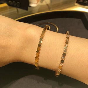 Detail of gold-finish honeycomb bangle with sparkling crystals on female wrist