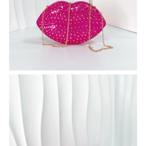Detail of pink lip-shaped clutch bag encrusted with rhinestones and gold chain