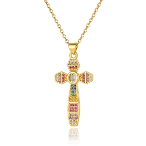 Macro detail of gold cross pendant with colorful cubic zirconia and white center stone