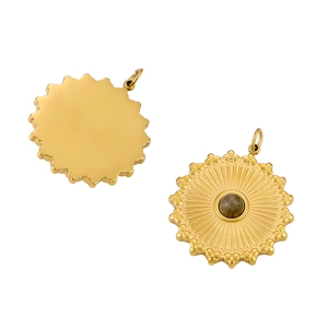 Detail of vintage gold sun pendant and round polished natural stone pendant set