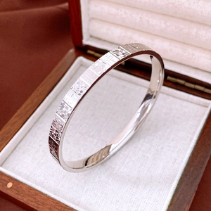Close-up of silver bangle with engraved Chinese characters for blessing and peace