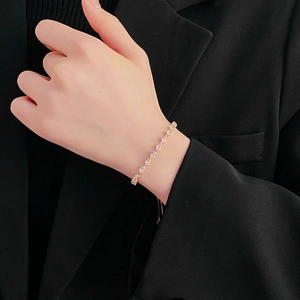 Detail of adjustable gold zircon bracelet with sliding clasp on woman's wrist