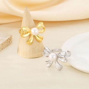 Elegant bow-shaped stainless steel rings with pearls in gold and silver finishes