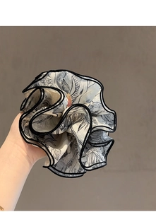 Primer plano de un coletero grande con estampado de tinta monocromática y pliegues capas
