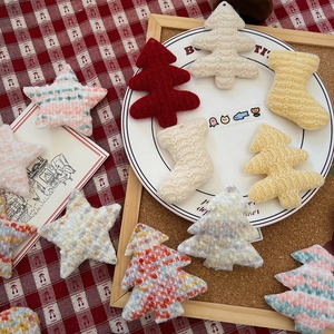Handcrafted knitted Christmas ornaments featuring trees and stars on a festive plaid background
