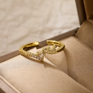 Detailed macro view of gold-plated crown ring with white zircon stones in jewelry box
