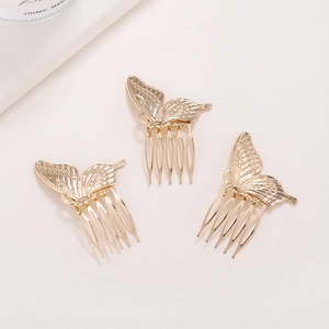 Three-piece golden butterfly hair combs with delicate hollow textures on cream background