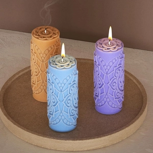Detailed relief mandala pattern on cylindrical scented candles in blue and purple