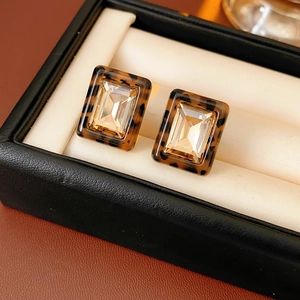 Detail of square resin leopard print earrings with champagne crystals in a luxury jewelry box