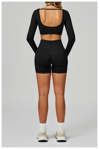 Close-up of black long sleeve yoga top with open back and V-seam high waist shorts