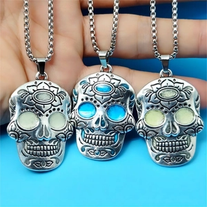 Close-up of three luminous sugar skull necklaces with detailed Mexican flower patterns