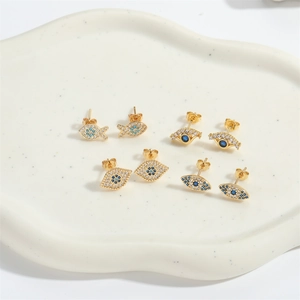 Gold plated evil eye stud earrings set with zircon micro-paving on a white tray