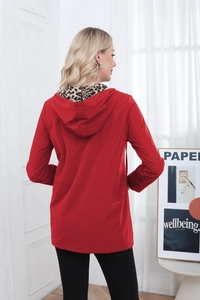 Detail of red hooded jacket showing chic leopard print lining and high-quality fabric texture