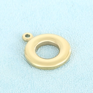 Pendentif rond doré poli pour la création de bijoux DIY sur fond bleu texturé