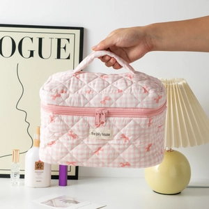 Pink checkered quilted makeup bag with red bow pattern and soft handle grip