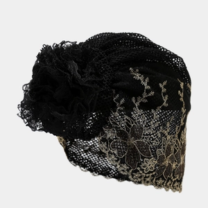 Detail of black lace turban with gold floral embroidery and 3D flower decoration