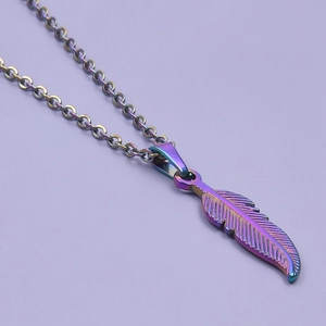 Macro shot of minimalist stainless steel feather necklace with rainbow finish pendant