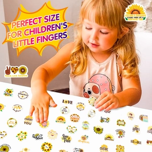 Close-up of a child applying sunflower stickers with positive English quotes on a surface