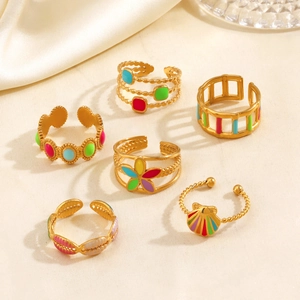 Lot de 6 bagues bohèmes en émail coloré avec finition dorée sur fond de soie blanche