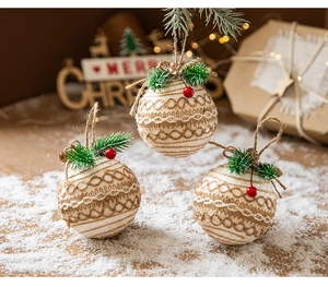Close-up of three festive plaid fabric Christmas ball ornaments with pine needles and cones