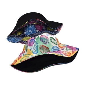 Reversible bucket hat for women with vibrant sea animal print and solid black side