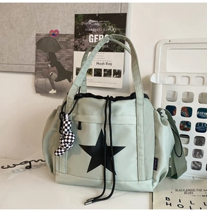 Detail of light green waterproof nylon tote bag with star print and checkerboard charm