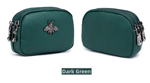 Close-up of dark green leather coin purse with double zippers and metal bee emblem
