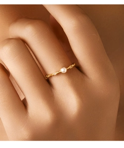 Close-up of vintage s925 silver gold-plated ring with central pearl and side crystal accents