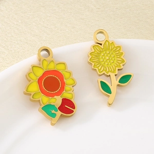 Golden sunflower enamel pendants in yellow and orange on a minimalist ceramic plate