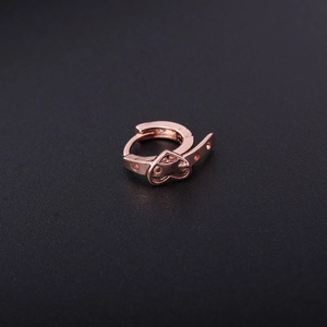 Detail of rose gold heart belt-buckle earring with a smooth polished finish and sharp details