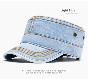 Detail of light blue denim flat top cadet hat with contrast yellow stitching and metal eyelets