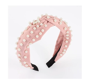 Close-up of pink velvet knotted headband featuring delicate white pearl embellishments
