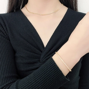 Elegant gold sparkling zircon tennis necklace and bracelet set worn by a fashion model