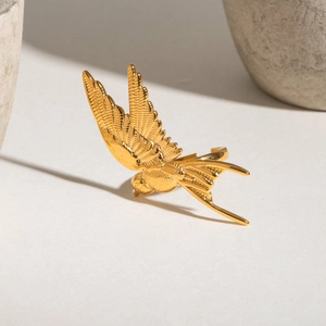 Polished gold stainless steel bird ring with detailed feather texture in a 45-degree view