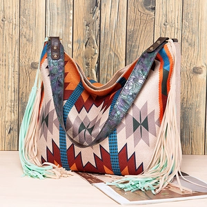 Detail of bohemian tote bag featuring geometric woven patterns and floral embossed straps